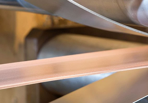 quality-control-clad-metal-specialties A close up of a machine that is making copper strips.